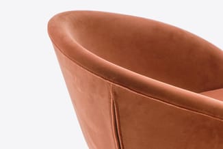 Terracotta bruine fauteuil met gesloten zijkanten en gebogen rugleuning, gedetailleerde close-up van de armsteun en bekleding