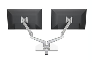 Dual monitor arm mount in zilver, bevestigd op basisvoet, twee zwarte schermen in landschapsformaat ondersteunend.