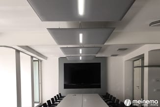Moderne vergaderruimte met witte wanden, grijze akoestische plafondpanelen met ingebouwde verlichting, witte vergadertafel en