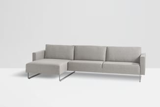 Grijze hoekbank met chaise longue links, metalen poten, tegen witte achtergrond.