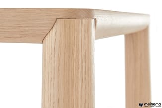 Houten vergadertafel met lichte eiken afwerking, detail van tafelblad en poot met rechthoekige vorm.