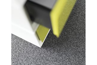 Grijze tapijtegel met gele en witte rand, geplaatst op donkergrijze vloerbedekking.