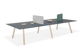 Lange vergadertafel met donkergrijs blad en houten poten, met grijze akoestische schermen en groene bureauscherm op het tafel