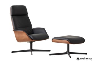 Relaxstoel met voetenbankje, zwart leren zitting, houten schaal in walnootkleur, zwart metalen onderstel, draaibaar.