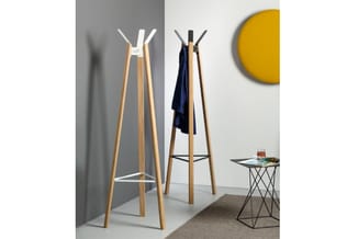 Twee houten kapstokken met witte en zwarte bovenstukken in een kantoorinterieur, naast een metalen bijzettafel en gele wandde
