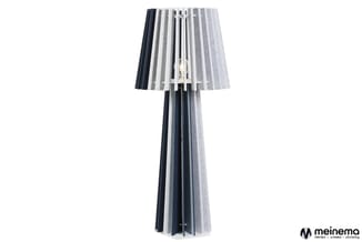 Staande lamp met plissé stoffen kap in grijstinten, donkergrijs en wit. Slanke conische voet met verticale textielstroken.