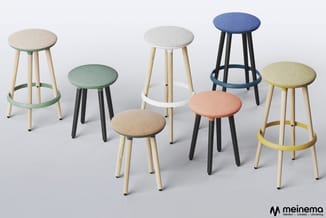 Acht krukken in verschillende kleuren met ronde zitting, houten poten en gekleurde voetsteun. Meinema-logo onderaan rechts.
