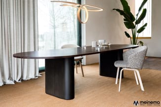 Moderne vergaderkamer met ovale zwarte houten tafel, grijze stoelen met witte poten, potplanten, gouden hanglamp en beige gor