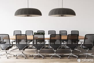 Vergaderzaal met lange houten tafel, zwarte mesh ergonomische kantoorstolen op wielen en twee grote grijze ronde hangende lam