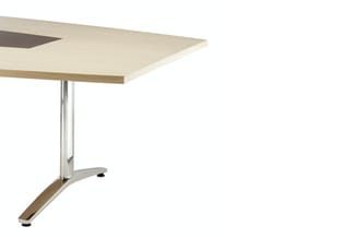 Kantafel met lichte houten blad en vleugelvormig uitstekend deel, ondersteund door chromen kolom op schuin inox voetframe.
