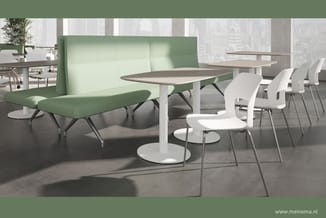 Moderne kantineruimte met groene boxbank, grijze tafel met wit onderstel, witte stapelstoelen en natuurlijk licht van grote r