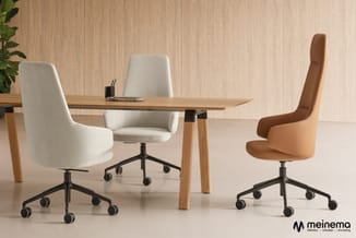 Houten bureau met drie draaibare werkstoefen in crème en cognackleur met zwarte kruisvoet, tegen houten wand met plant.