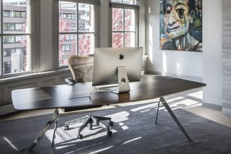 Modern kantoor met zwart bureau aan ramen, draaibare bureaustoel, Apple iMac, witte wand en abstract schilderij.