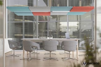 Moderne vergaderruimte met witte tafel, grijze draaistoelen, grote ramen en kleurrijke hangende akoestische panelen in blauw,