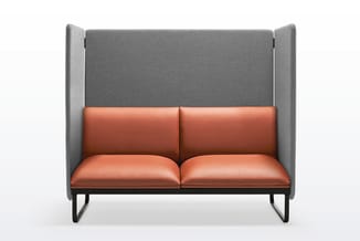 Moderne boxbank met grijze fluweelachtige wanden en terracottakleurig leren zitgedeelte op zwart metalen frame.