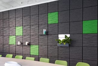 Moderne kantoorwand met zwarte structuurpanelen, groen verlichte vakken en zwevende houten planken. Groene bureaukstoelen aan