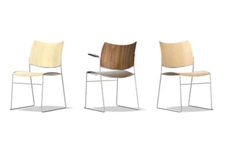 Drie moderne stoelen met stalen frame: twee met licht hout, één met donker hout en grijze zitting, tegen witte achtergrond.