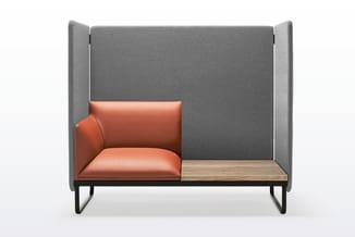 Grijze akoestische vergadercel met rood-oranje zitgedeelte links en houten tafelblad rechts, op zwart metalen frame.