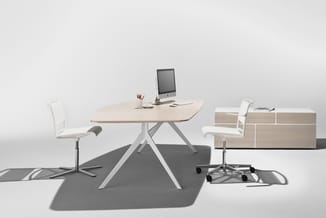 Modern kantoor met lichte houten ronde tafel op wit onderstel, twee witte bureaustoelen, grijze vloermat en houten opbergkast