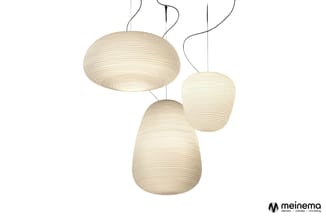 Drie hangende textiel pendant lampen in crème-wit, verschillende maten, met ribbel textuur en gebogen bevestigingskabels.