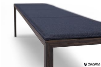 Houten vergadertafel met donkerblauwe textielblad en zwart houten frame, detailview zijkant.