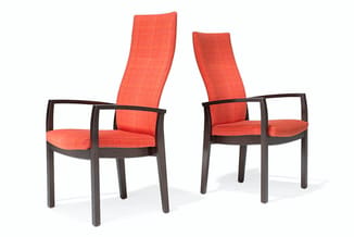 Twee rode gestoffeerde fauteuils met hoge rugleuning en donker houten frame, naast elkaar tegen witte achtergrond.