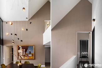 Moderne kantoorruimte met verticale bruine lamelbekleding, hangende pendels, frameloos schilderij, gouden vaas en groene stoe