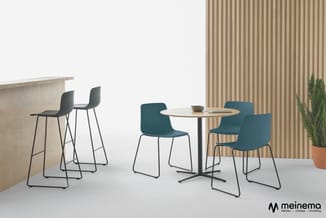 Kantoorinrichting met toonbank, zwarte barkrukken, ronde tafel met vier groenblauwe stoelen op metalen poten, houten wandpane
