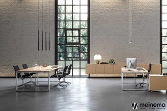 Modern kantoorinterieur met houten bureaus, zwarte werkstoel, wandkast, hangende verlichting en grote raampartijen met stalen