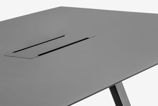 Grijze vergadertafel met geïntegreerde zwarte ventilatiesleuven en zwart metalen poot, bovenaanzicht.