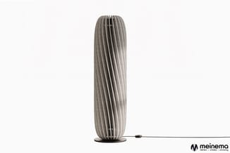 Grijze staande akoestiekpaneel met verticale latten, ovale vorm, op zwart voetstuk met stroomkabel.