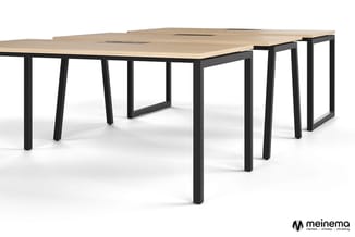 Vergadertafel met licht houten blad en zwart metalen frame, modulair opgesteld in L-vorm met meerdere werkplekken.