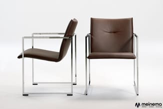 Twee bruinleren stoelen met chromen frame: links zijwaarts gepositioneerd, rechts frontaal. Meinemo-logo onderin.