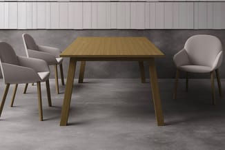Houten eettafel met vier grijze stoelen in moderne kantoorinrichting met betonnen vloer en lichtgrijze wandpanelen.