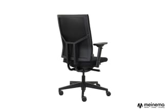 Zwarte ergonomische bureaustoel met hoog netrug, verstelbare armleuningen en wieltjes op vijfpunts voetkruis, tegen witte ach