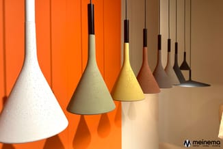 Hangende kegellampen in verschillende aardetinten met donkerbruine fitringen, tegen oranje en beige achtergrond.