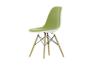 Moderne stoel met groen-witte kunststof zitting, witte rand, houten poten en zwarte kruisverbindingen.