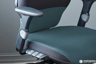 Groene ergonomische bureaust­oel met zwarte mesh-rugleuning, zilverkleurige metalen armleuning en zitting met bedieningsknopp