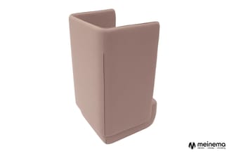 Roze stofbeklede fauteuil met hoge rugsteuning en afgeronde vormen, aanzicht vanaf de zijkant tegen witte achtergrond.