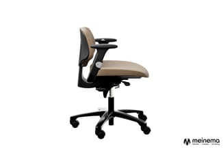 Ergonomische bureaustoel met beige zitting, zwarte rugleuning en armsteunen, op zwart voetkruis met wielen.