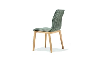 Moderne stoel met groen gestoffeerde, verticaal geribbelde rugleuning en zitting op natuurhouten houten frame, tegen witte ac