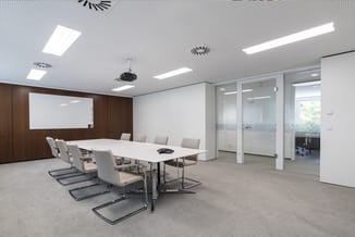 Moderne vergaderruimte met witte rechthoekige tafel, beige stoelen met zwart frame, bruine houten achterwand, whiteboard, pla