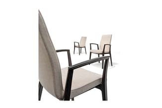 Moderne stoelen met zwarte houten frames en beige stoffering. Voorgrond: stoel met hoge rugleuning. Op achtergrond: drie verd
