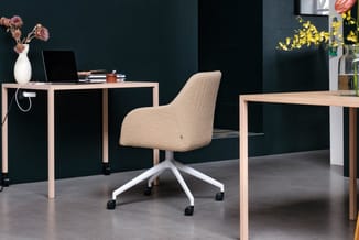 Moderne kantoorruimte met houten bureaus, beige draaibare bureaustoel met wit onderstel, donkergroene muur, decoratieve bloem