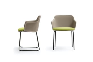 Twee grijsgroene stoelen met zwart metalen frame en groengeelkussentje op zitting, één vooraanzicht en één zijaanzicht.