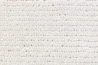 Textieldetail van een witte/crèmekleurige stofbekleding met horizontale structuurlijnen en korrelachtig geweven oppervlak.