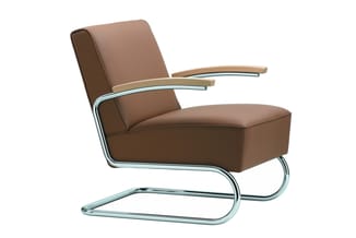 Bruine leren loungestoel met chromen buisvormig frame en houten armleuningen, op wit oppervlak.