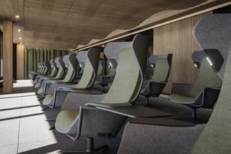 Rij grijze en groene ergonomische bureaustoelen met hoofdsteunen in moderne kantoorruimte met houtafwerking en verticale wand