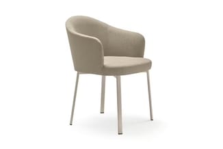 Beige stoel met afgeronde rugleuning en armleuningen, zitting in licht textielweefsel, vier grijze metalen poten.
