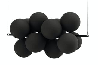 Zwarte akoestische bollen opgehangen aan zwarte stang tegen witte wand.